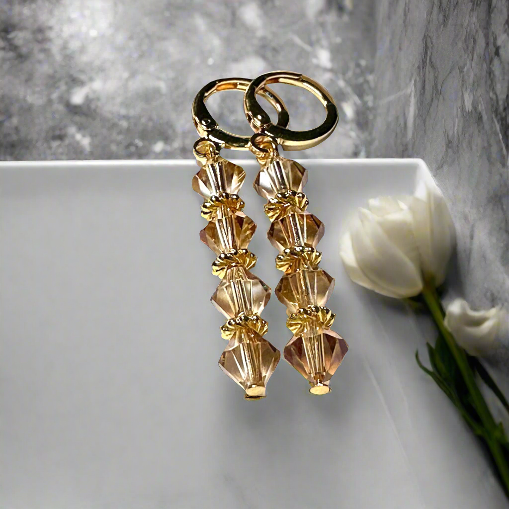 Introducing our Swarovski Crystal Bicone Topaz Dangle Earring. Made with high-quality 14K gold plating and accented with sparkling topaz crystals