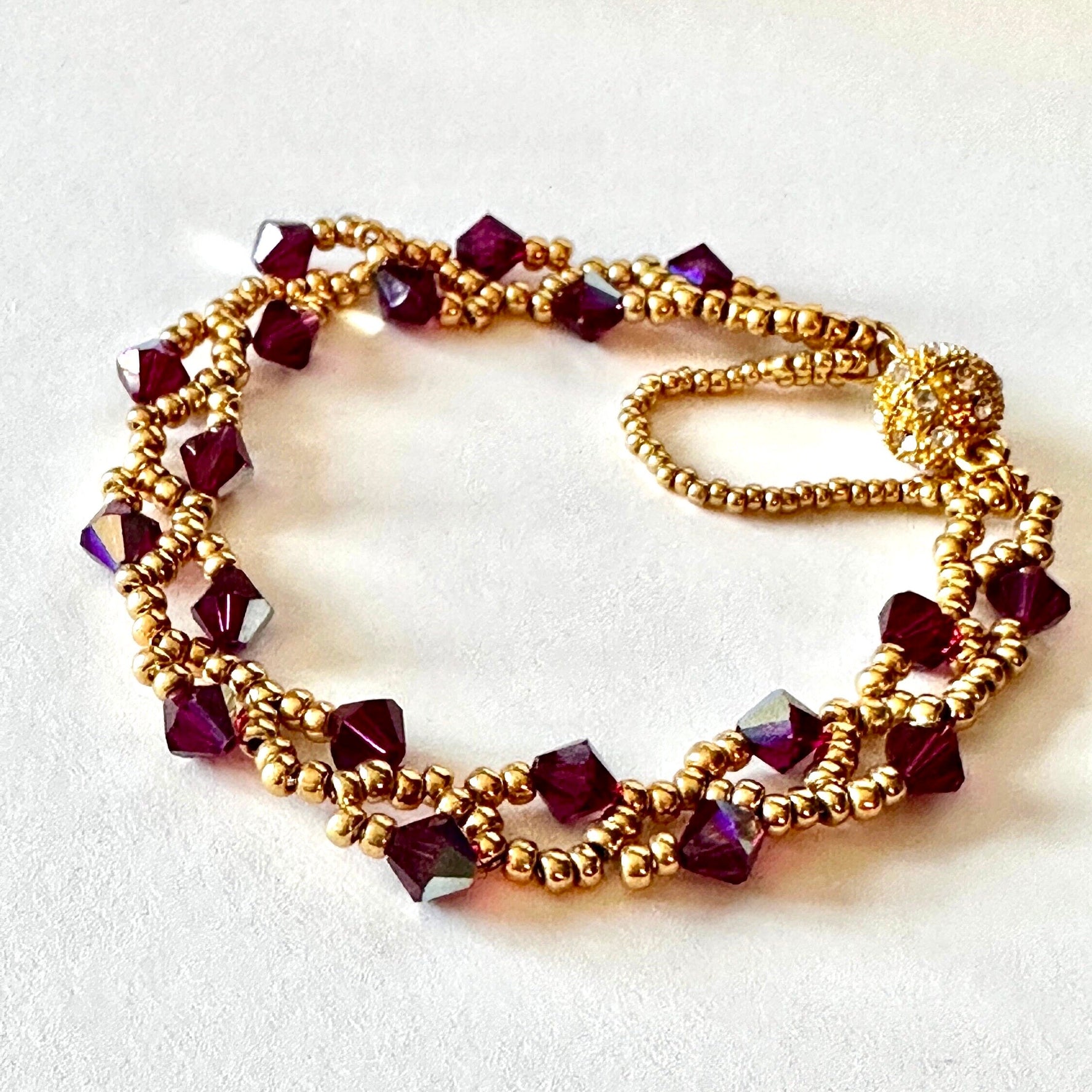 This Ruby Swarovski Crystal bicone Vine Bracelet is crafted using Gold Miyuki seed beads